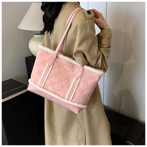 Close-up of pink embossed tote bag with white plush fur trim and golden logo plate