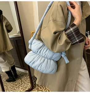 Detail of light blue ruched cloud bag showing plush texture and knotted shoulder strap