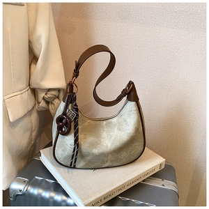 Detail view of retro crescent underarm bag in sage green with brown leather trim and knot charm
