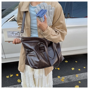Détail d'un sac cabas marron foncé en simili cuir vintage avec de longues bretelles souples
