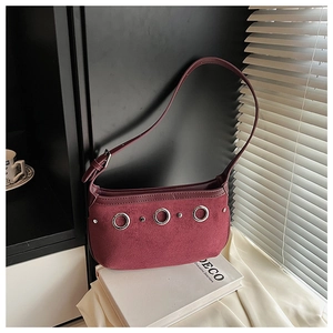 Detail of burgundy faux suede hobo bag with silver ring hardware and buckle strap