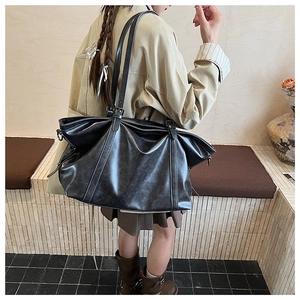 Gros plan d'un grand sac cabas noir en similicuir avec finition cirée vintage et fines anses