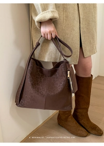 Detail of dark brown leopard embossed tote bag with adjustable strap and small pouch