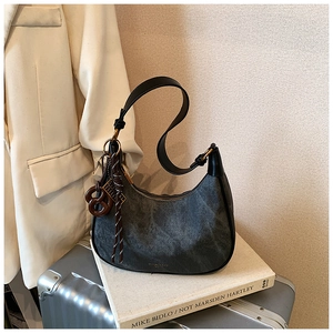 Detailed macro view of dark grey hobo bag with vintage texture and stylish resin pendant