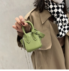 Detail of micro bucket bag in green pebble leather with silver chain strap
