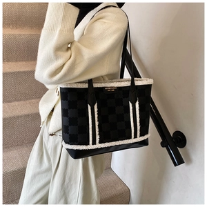 Detail of plush拼接 fleece trim on black checkerboard tote bag for women's winter fashion