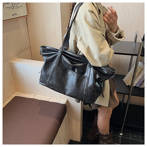 Détail d'un grand sac fourre-tout noir en similicuir vintage avec boucle métallique