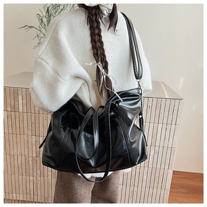 Détail d'un grand sac cabas en cuir ciré noir avec bandoulière large pour le quotidien
