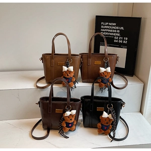 Detail of four retro bucket bags in brown and black with plush bear charms