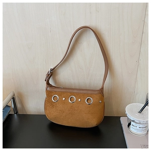 Detailed close-up of brown suede hobo bag with vintage texture and silver rings