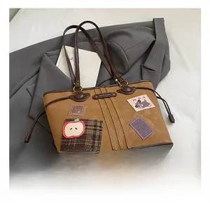 Détail du sac cabas rétro en daim avec broderie chien et bandoulière en cuir marron