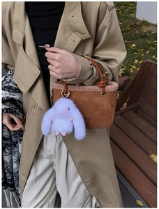 Borsa a secchiello marrone in pelle smerigliata con bordo in peluche e ciondolo a coniglio