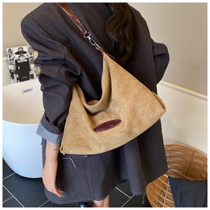 Detail view of large camel suede hobo bag with adjustable strap on female model