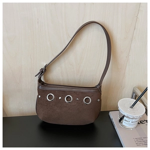 Detailed close-up of brown suede hobo bag featuring silver eyelets and leather trim edge