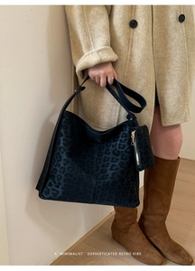 Detail of leopard print bucket bag with matching coin purse on minimalist beige coat