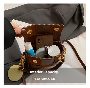 Detail of woven crossbody bag showing internal capacity for phone and cosmetics