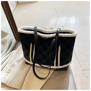 Detail of black tote bag with white faux shearling trim and stylish leather shoulder straps