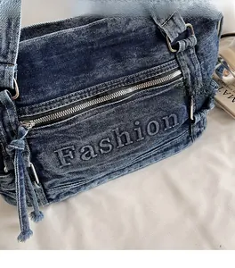 Detailed macro view of the dark blue denim tote bag with embossed Fashion lettering