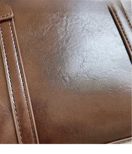 Close-up of premium brown leather texture with neat stitching and glossy finish