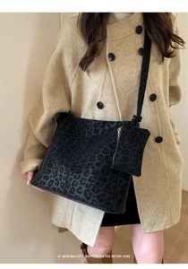 Detail shot of black leopard print shoulder bag set with a matching small zipper pouch