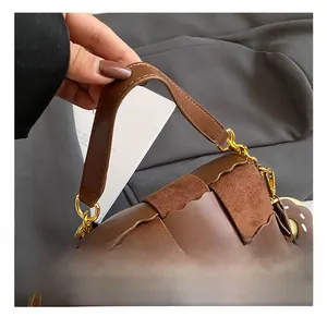 Detail of brown woven tote bag with wavy suede patchwork and gold chain hardware