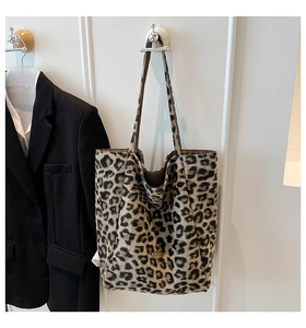 Dettaglio borsa shopper leopardata con logo in metallo dorato e doppi manici sottili