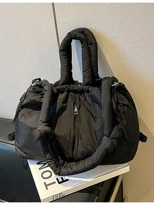 Quilted black puffer tote bag with knotted shoulder strap and spacious nylon design