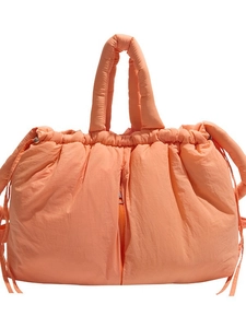 Quilted orange puffer tote bag with drawstring closure and front zipper detail