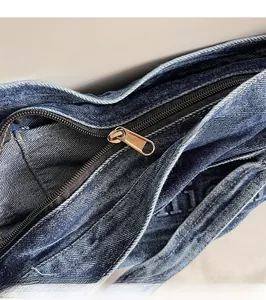 Detail of high-quality metal zipper and smooth dark blue denim fabric on tote bag
