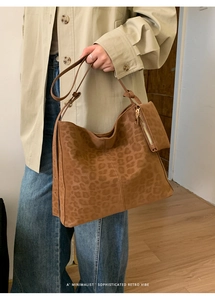 Detailed close-up of leopard print suede tote bag with matching zip pouch accessory