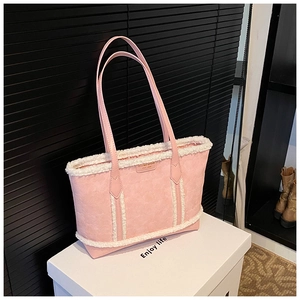 Detail of pink faux suede tote bag with white plush trim and metallic logo plate