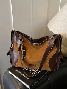 Large suede and leather tote bag with vintage beads in a minimalist room interior