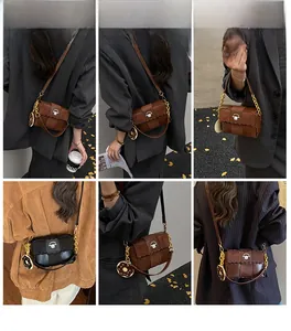Détail d'un sac bandoulière rétro bimatière avec rabat festonné et breloque donut
