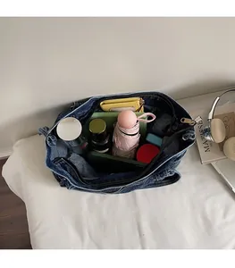 Top view showing the spacious interior of the blue denim tote bag with daily essentials