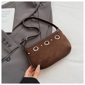 Detailed close-up of dark brown suede hobo bag with silver ring hardware and studs