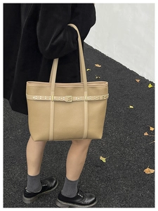 Top view of khaki lychee leather tote bag featuring rivet belts and metal buckles