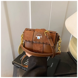 Détail du sac en cuir marron avec motif de chiot dessin animé et chaîne dorée