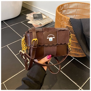 Détail du sac bandoulière marron foncé avec imprimé chiot et bandoulière chaîne dorée