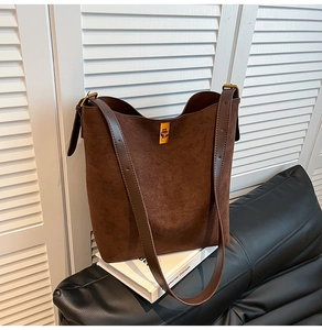Dettaglio della borsa hobo in camoscio marrone con fibbia a rotazione in metallo dorato