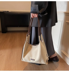 Detail of a minimalist beige tote bag with brown straps in a lifestyle interior setting