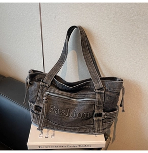 Detail of grey denim tote bag with 3D Fashion embroidery and functional zip pocket