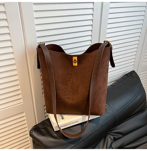 Dettaglio della fibbia girevole in metallo dorato su una borsa tote in pelle scamosciata