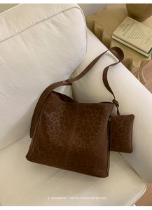 Detail of leopard print bucket bag and mini purse set on a white fabric sofa