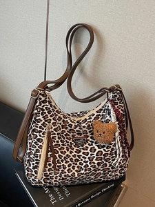 Leopard print hobo bag with brown leather strap and plush bear charm for daily use