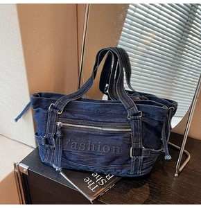 Detail of blue denim tote bag with side drawstrings and Fashion embossed pocket