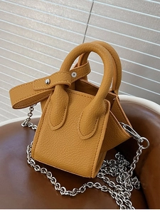 Mini mustard yellow bucket bag with pebbled leather texture and silver chain strap