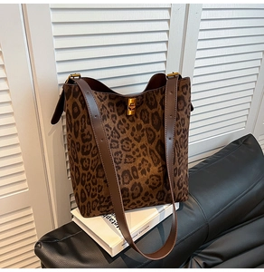 Dettaglio della borsa a secchiello leopardata con chiusura dorata e tracolle in pelle
