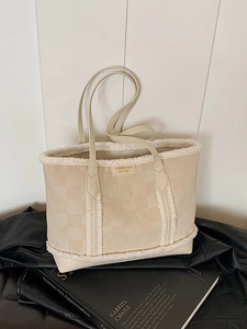 Creamy beige tote bag with clover embossing and white shearling trim on leather jacket