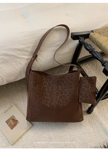 Detail of dark brown hobo bag with subtle leopard print and matching mini pouch bag