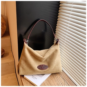 Macro detail of the khaki suede hobo bag with burgundy leather handle and contrast panel